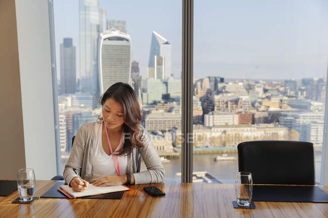 Businesswoman working in highrise office conference room — Stock Photo