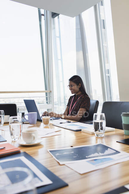 Femme d'affaires travaillant à l'ordinateur portable dans la salle de conférence — Photo de stock