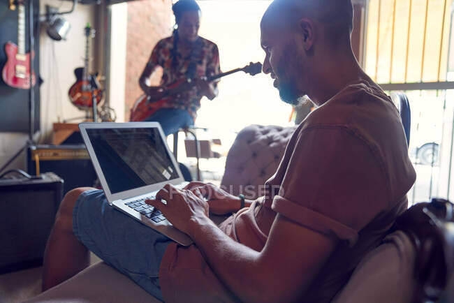 Músicos com laptop e guitarra em estúdio de gravação — Fotografia de Stock
