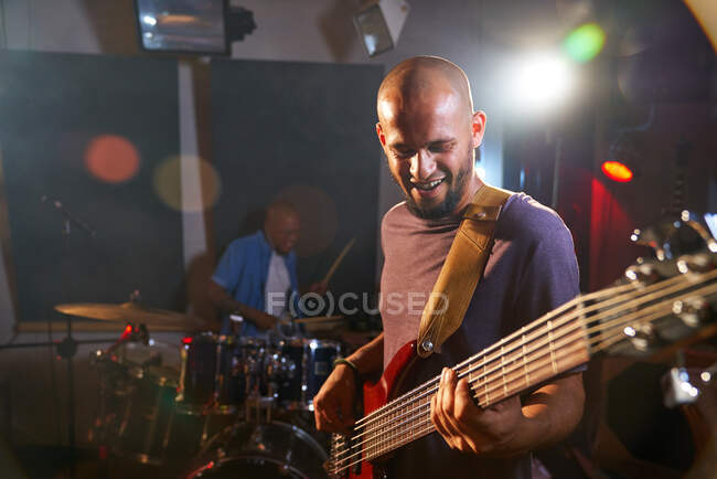 Male guitarist and drummer performing on stage — Stock Photo