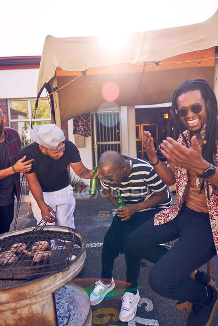 Happy friends barbecuing in sunny parking lot — Stock Photo