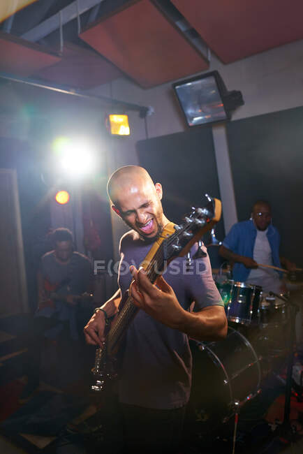 Male musician playing guitar in recording studio — Stock Photo