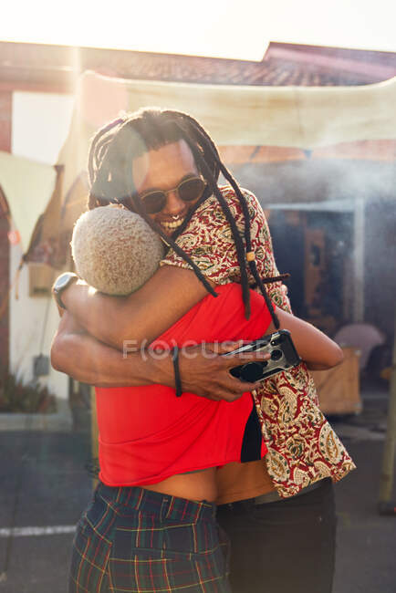 Feliz casal abraçando no ensolarado estacionamento — Fotografia de Stock