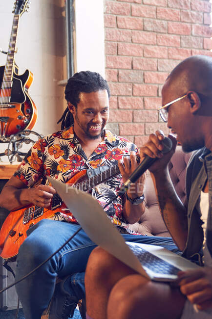Мбаппе с ноутбуком и электрогитарой в студии звукозаписи — стоковое фото