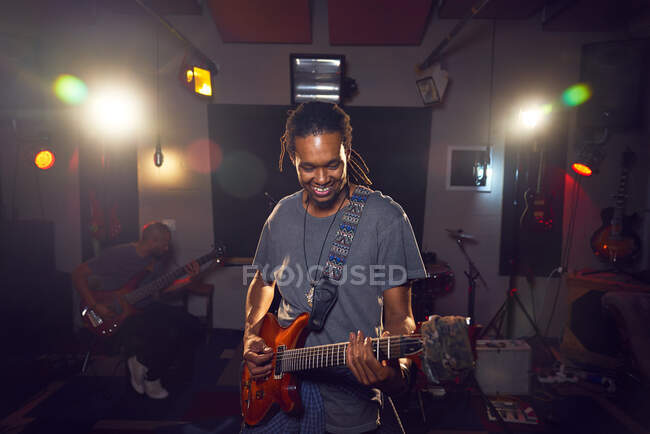Чоловічий музикант грає на гітарі в студії звукозапису. — стокове фото