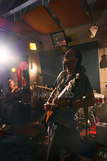 Musicista maschile che suona la chitarra in studio di registrazione — Foto stock