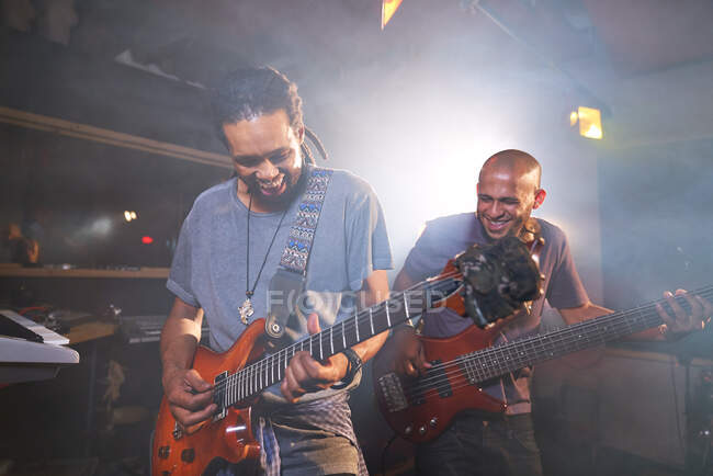 Músicos masculinos felizes tocando guitarra elétrica em estúdio de gravação — Fotografia de Stock