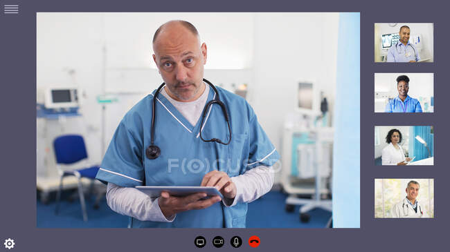 Doctor video conferencing with colleagues during COVID-19 pandemic — Stock Photo