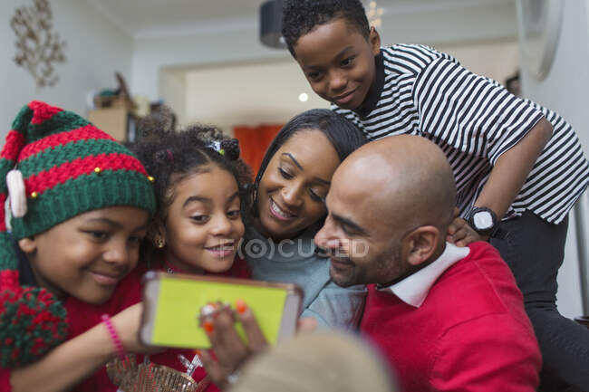 Счастливая семья делает рождественское селфи со смартфоном — стоковое фото