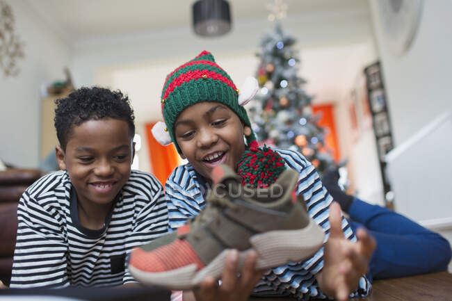 Felices hermanos consiguiendo nuevas zapatillas para Navidad - foto de stock