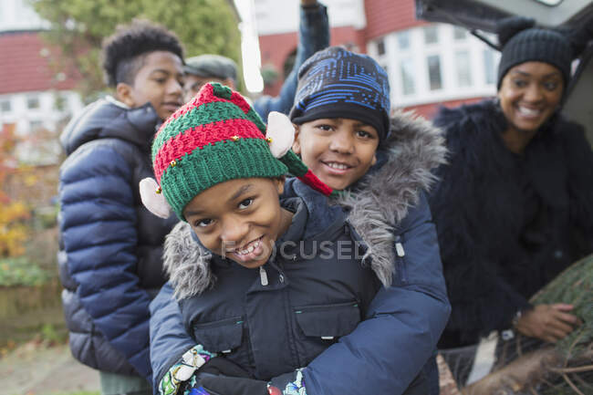 Portrait happy brothers in winter coats and hats hugging — Stock Photo