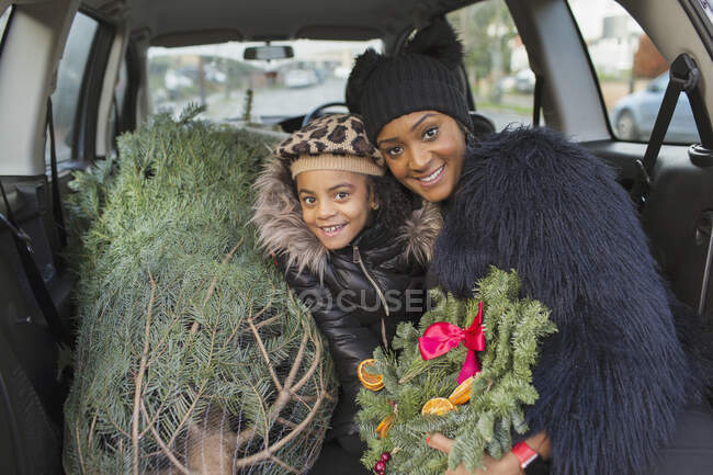 Retrato mãe feliz e filha com árvore de Natal no carro — Fotografia de Stock
