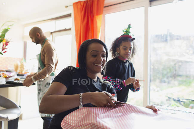 Glückliche Mutter und Tochter wickeln Weihnachtsgeschenke ein — Stockfoto