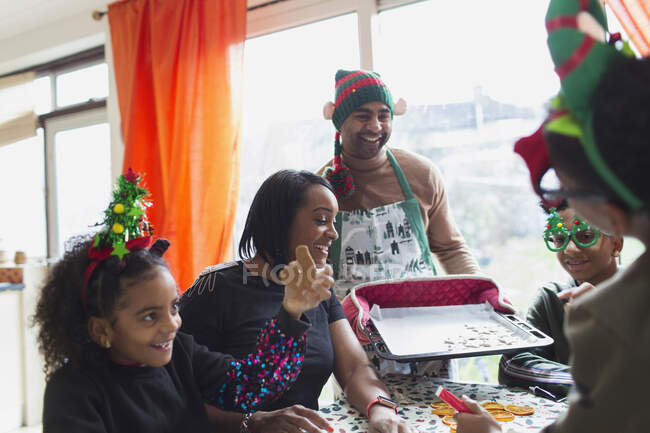 Happy family baking and eating Christmas cookies at table — Stock Photo