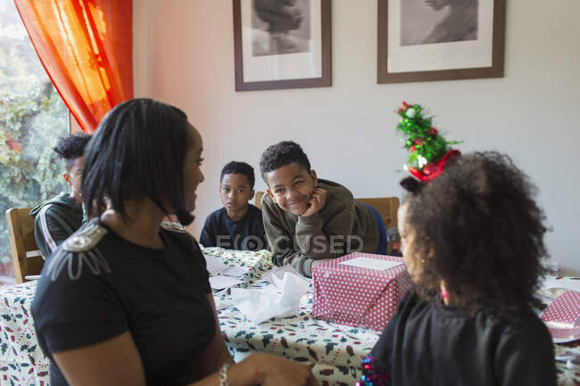 Bonne famille enveloppant cadeaux de Noël à la table — Photo de stock