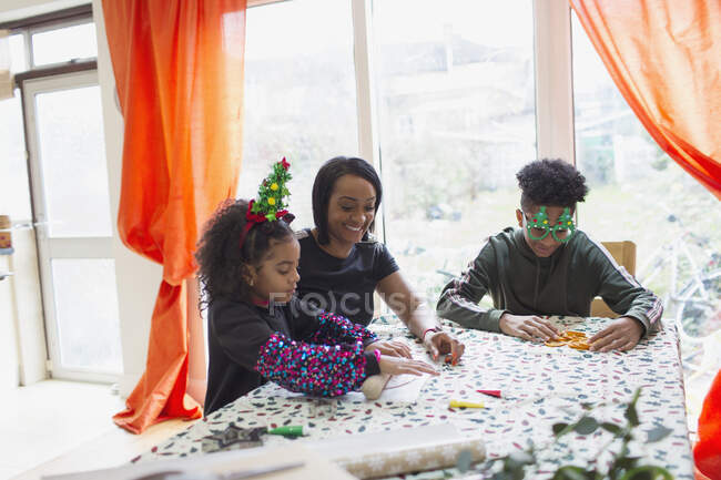 Mamma e bambini che fanno biscotti di Natale a tavola — Foto stock