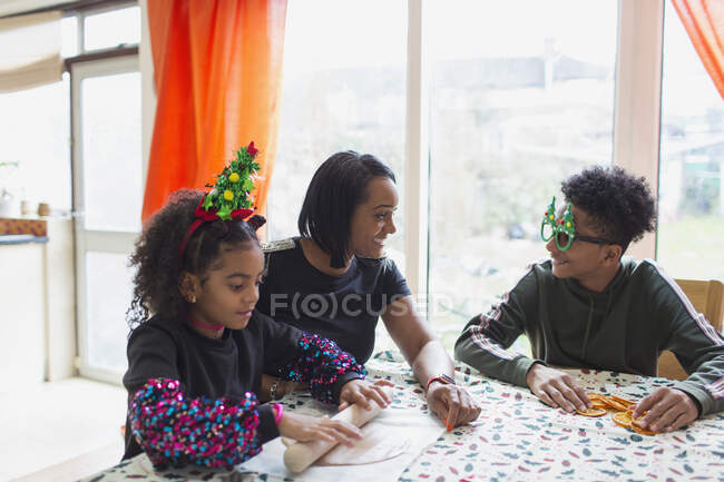 Счастливая мать и сыновья готовят рождественские блюда за столом — стоковое фото