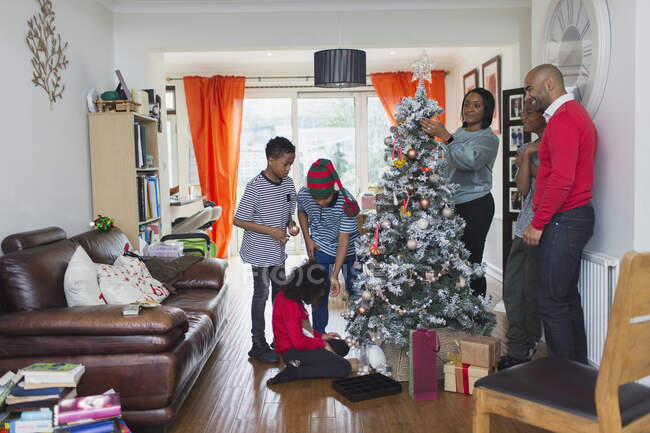 Family decorating Christmas tree in living room — Stock Photo