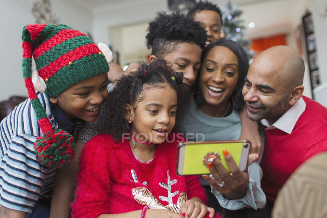 Happy family taking Christmas selfie with smart phone — Stock Photo