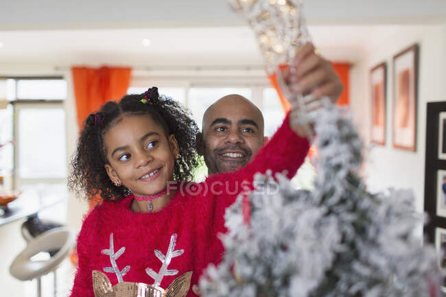 Feliz padre e hija decorando el árbol de Navidad - foto de stock