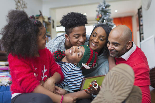 Feliz familia celebrando la Navidad en el salón - foto de stock
