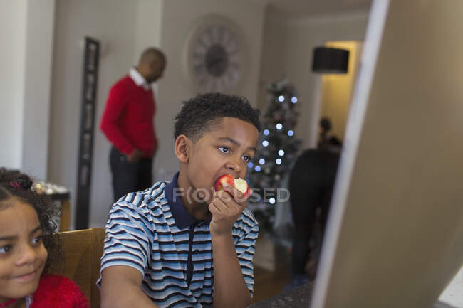 Menino comendo maçã em casa — Fotografia de Stock