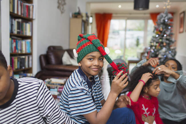 Retrato menino festivo usando chapéu de Natal na sala de estar — Fotografia de Stock