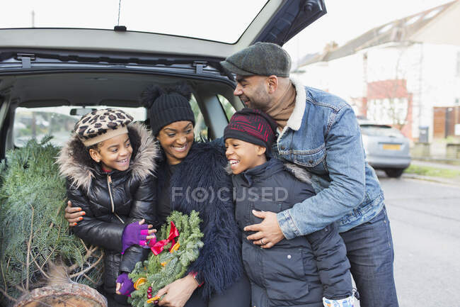 Happy family with Christmas tree in car — Stock Photo