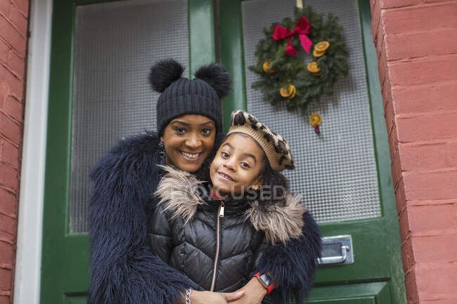 Portrait happy mother and daughter hugging on front stoop — Stock Photo