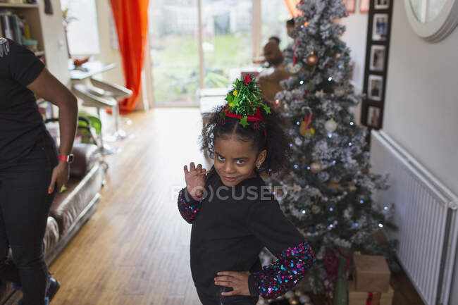 Portrait sassy girl in hat by Christmas tree — Stock Photo