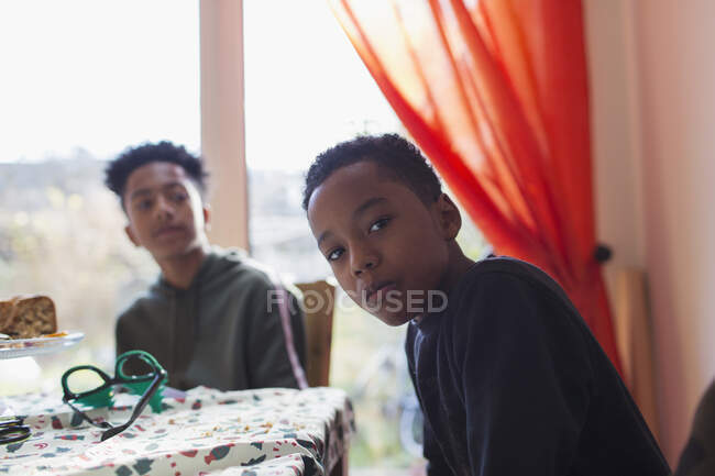 Portrait serious brothers at dining table — Stock Photo