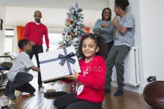 Retrato menina feliz com presente de Natal na sala de estar — Fotografia de Stock