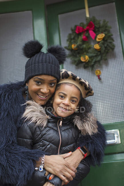 Portrait happy mother and daughter hugging on front stoop — Stock Photo