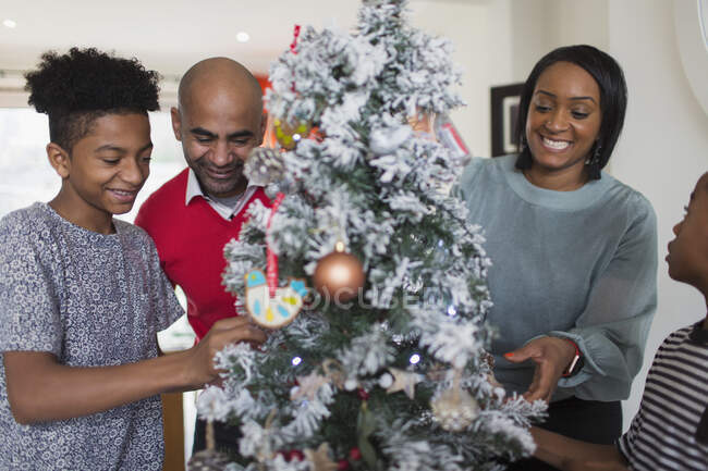 Happy family decorating Christmas tree — Stock Photo