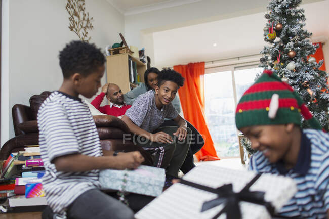 Familie öffnet Weihnachtsgeschenke im Wohnzimmer — Stockfoto