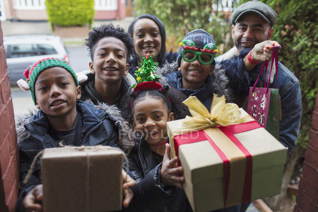 Ritratto famiglia felice che arriva con regali di Natale alla porta d'ingresso — Foto stock