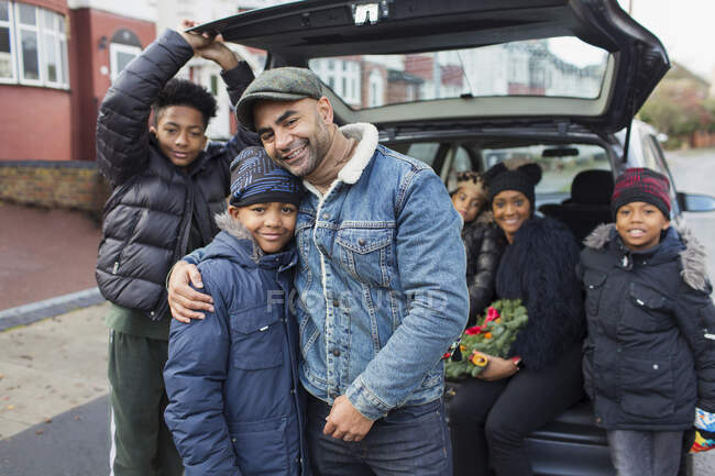 Retrato familia feliz abrazo en la parte posterior del coche - foto de stock