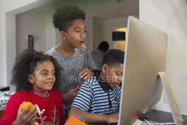 Brothers and sister using computer — Stock Photo