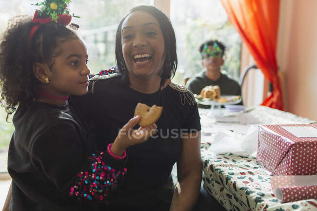 Retrato feliz madre e hija comiendo galletas de Navidad - foto de stock