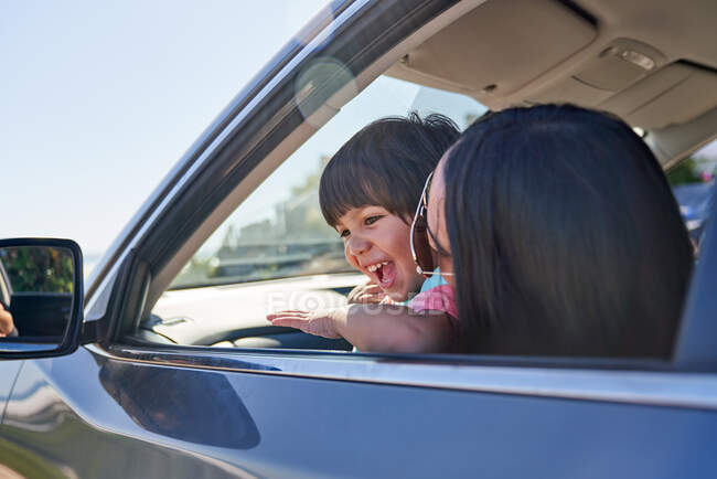 Mãe e filho felizes em carro ensolarado — Fotografia de Stock
