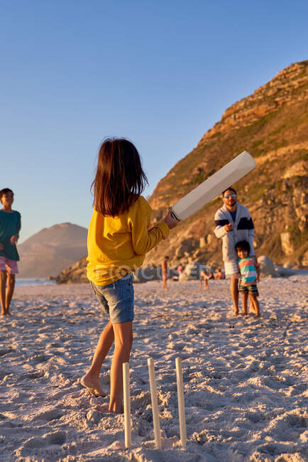 Family playing cricket on summer beach — Stock Photo