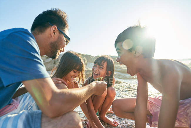 Famiglia felice che gioca sulla spiaggia soleggiata — Foto stock