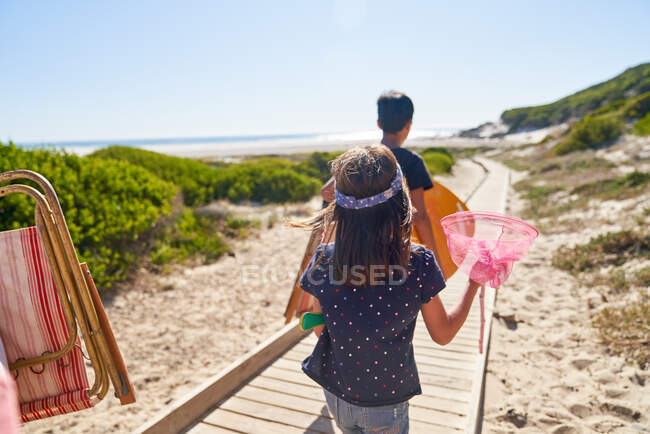 Fille portant filet papillon sur la plage ensoleillée promenade — Photo de stock