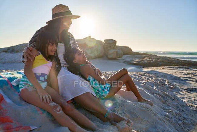 Mãe e filhas relaxando na praia ensolarada — Fotografia de Stock