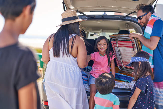 Ragazza felice con crema solare sul naso con la famiglia in auto — Foto stock