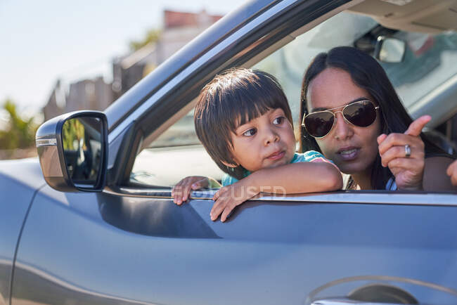 Mãe e filho olhando para a janela do carro ensolarado — Fotografia de Stock