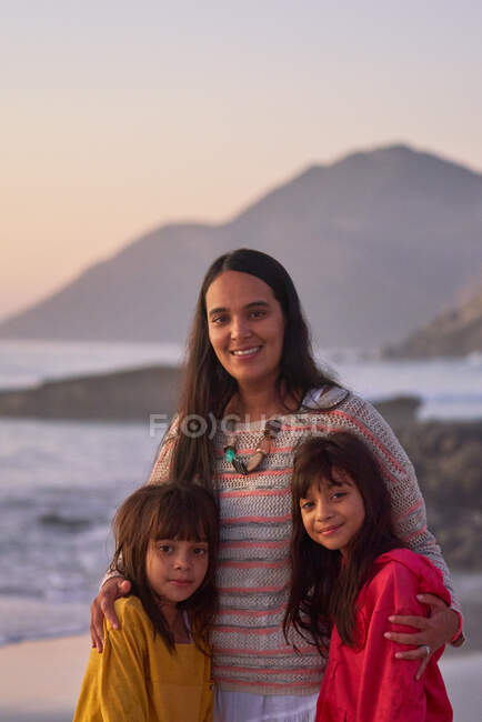 Retrato feliz madre e hijas en la playa - foto de stock