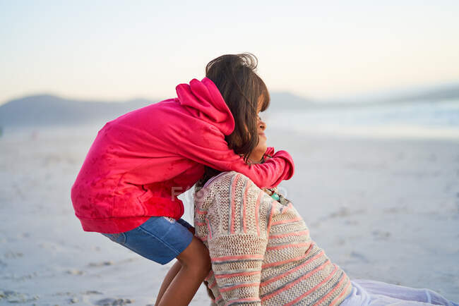 Carinhoso filha abraçando mãe na praia — Fotografia de Stock