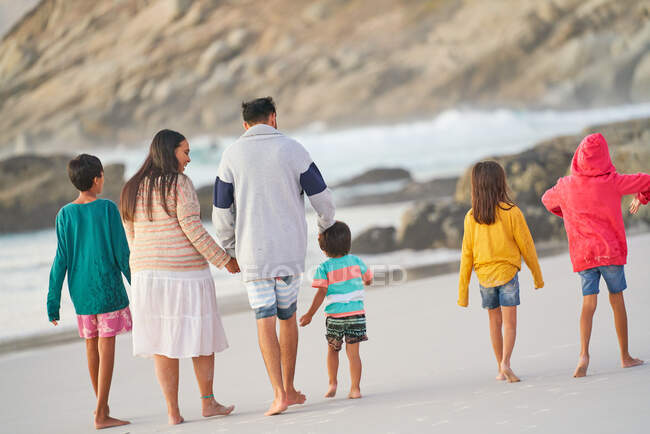 Familia caminando en la playa - foto de stock