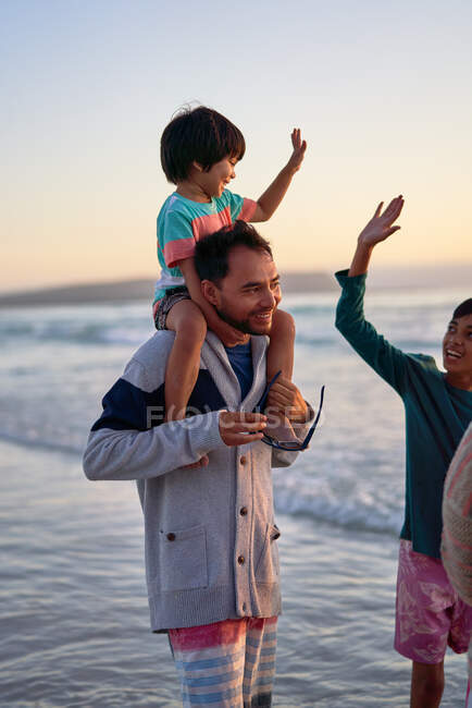 Familia feliz vadeando en el océano surf - foto de stock
